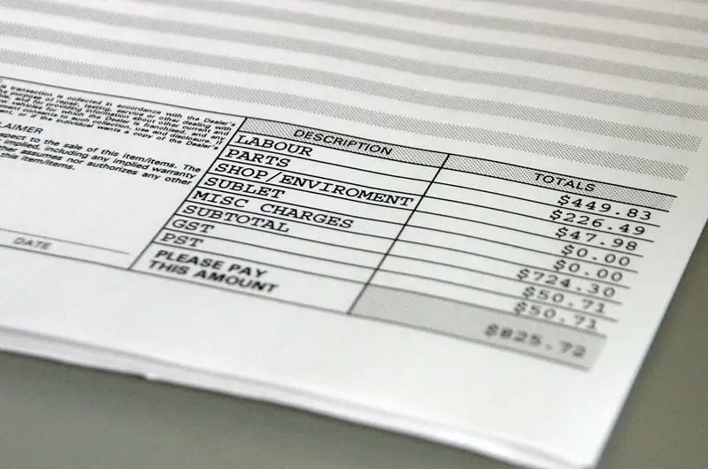 Close-up van een factuur met omschrijving en bedragen, met onderaan de regel 'please pay this amount'