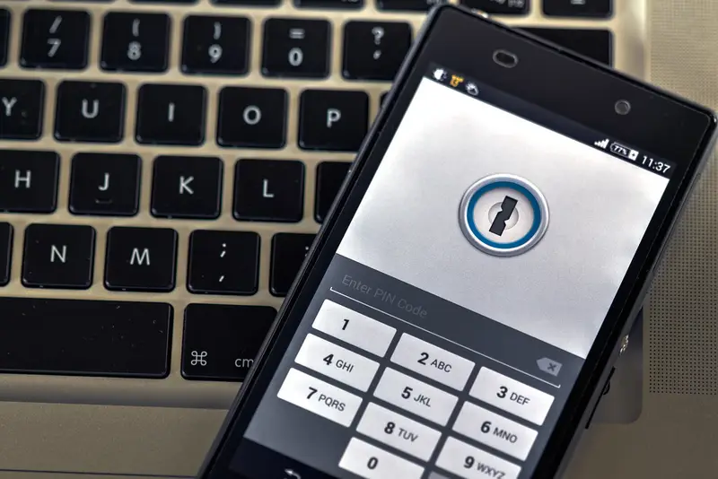 Smartphone met vergrendelscherm en pincode op een laptoptoetsenbord