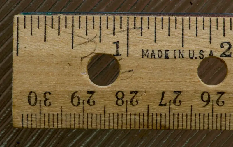 Houten liniaal met zowel inch- als millimeterverdeling