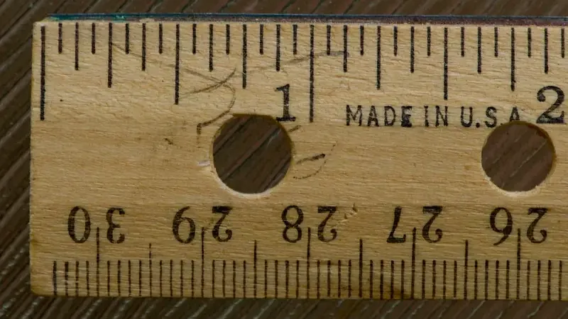 Houten liniaal met zowel inch- als millimeterverdeling