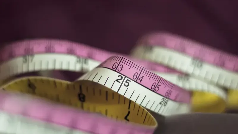 Rolmaat en linialen met inch- en centimeterverdeling naast elkaar
