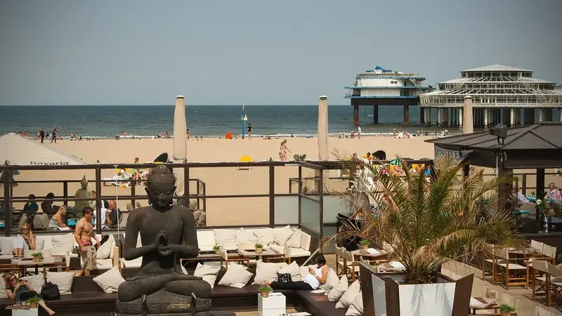Zonnig strand van Scheveningen met pier en strandtenten